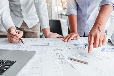 Zeichnungen auf einem Tisch werden durch Gestik und Händen besprochen