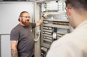 Zwei Mitarbeitende vor einer technischen Anlage