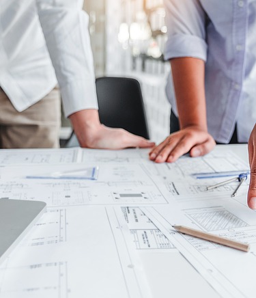 Zeichnungen auf einem Tisch werden durch Gestik und Händen besprochen