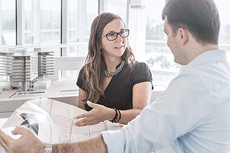 Zu sehen sind zwei Planer die sich über Sanierung und Umbau einer Bestandsimmobilie unterhalten