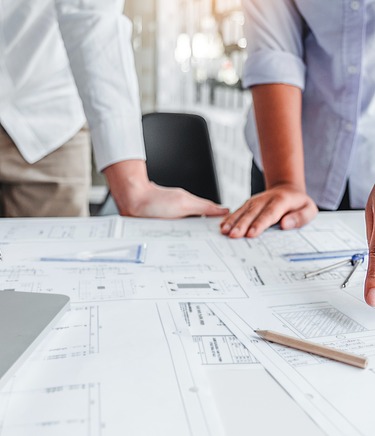 Zeichnungen auf einem Tisch werden durch Gestik und Händen besprochen