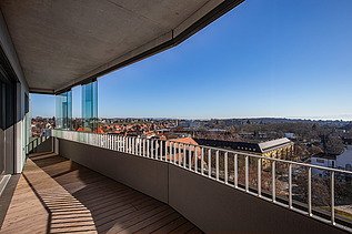 Balkonansicht vom Gbeäude aus mit modernem Gelände bei Sonnenschein