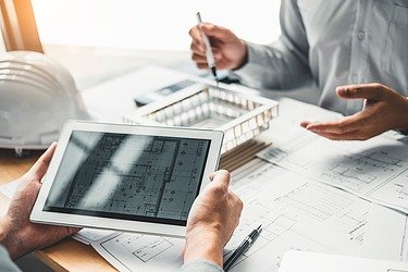 Architektonisches 3D Modell und ein Tablett in einer Gesprächssituation