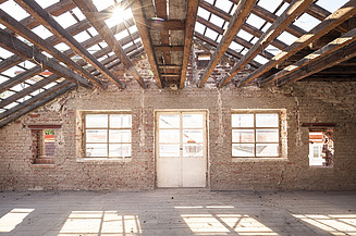 Lichtdurchflutete Fensterfront im Baubestand mit Ziegelsteinen und Holzelementen der Decke 