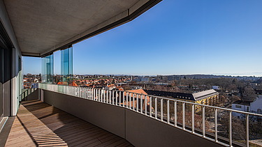 Balkonansicht vom Gbeäude aus mit modernem Gelände bei Sonnenschein