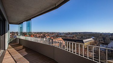 Balkonansicht vom Gbeäude aus mit modernem Gelände bei Sonnenschein