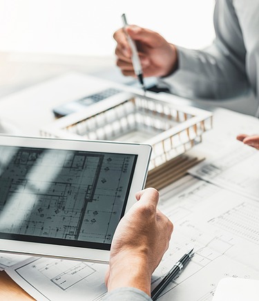Architektonisches 3D Modell und ein Tablett in einer Gesprächssituation