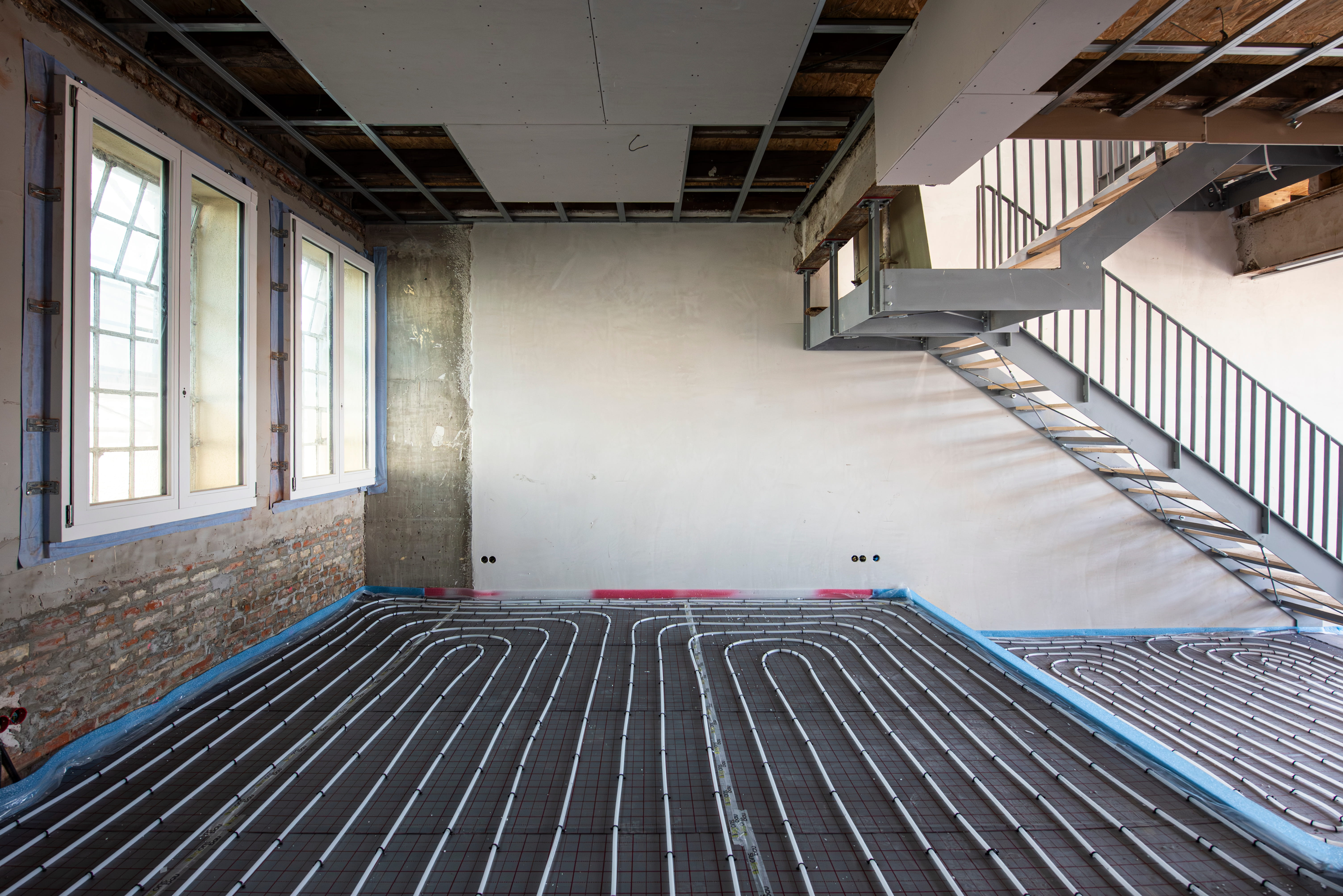 Sanierungsarbeiten und verlegte Fußbodenheizung im Rohbau