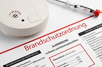 Brandschutzordnung auf einem Plan mit Schraubenzieher und Feuermelder