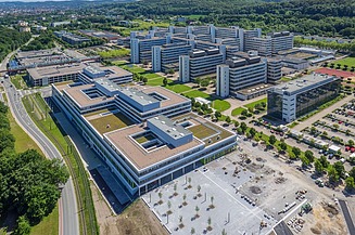 Universität Bielefeld Universitätscampus von oben mit drei flachen Blocks und Parkplatz im Vordergrund und 5 riegelförmigen Bauten dahinter